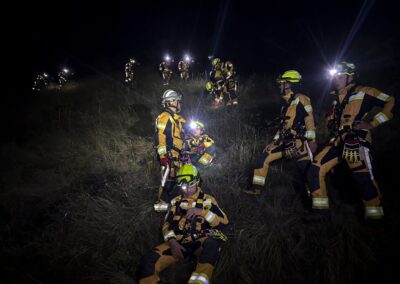 Pompiers du CSI Hérens progressant de nuit avec lampes frontales.
